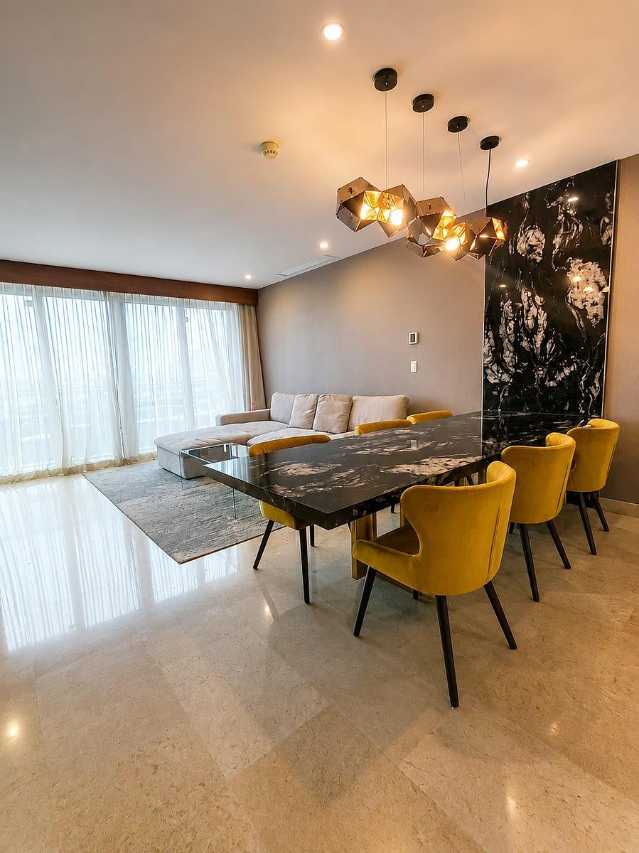Comedor y sala con muro de mármol en departamento de Santa María, Monterrey