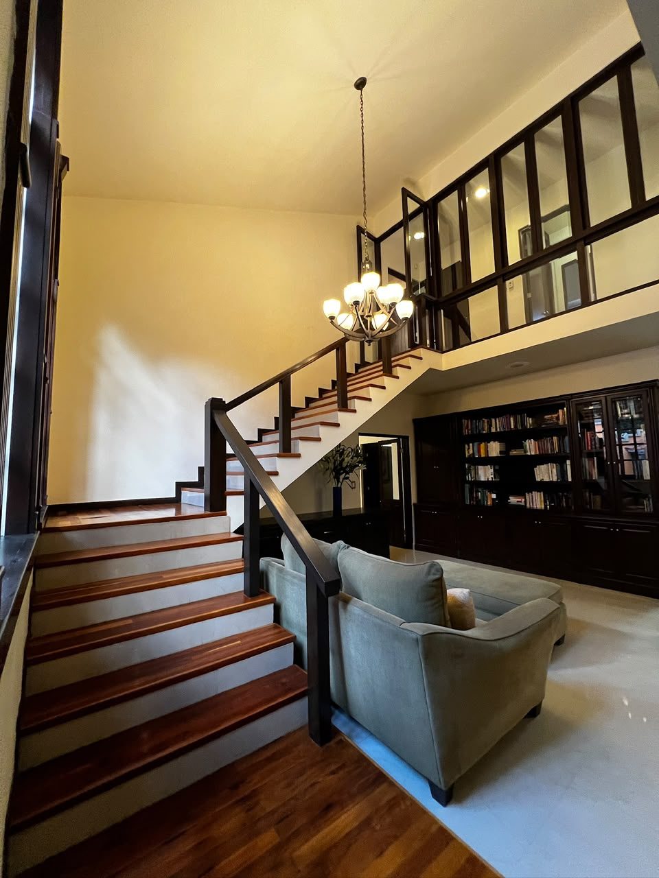 Escalera de madera sólida junto al librero de doble altura